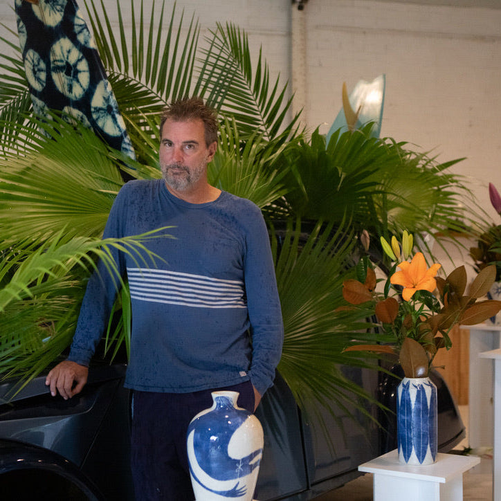Damion Fuller standing in a room with plants and decorative vases