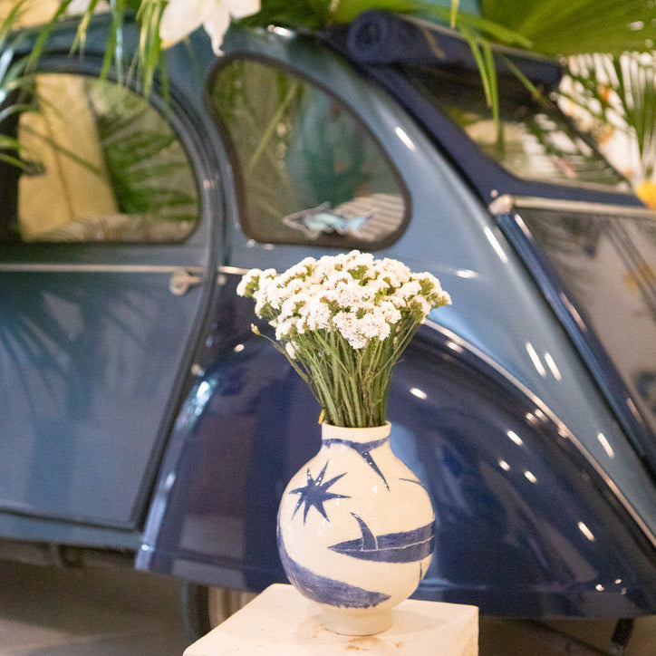Vintage blue car with a vase by Damion Fuller of flowers in front